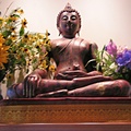 Buddha rupa adorned with summer flowers.jpg